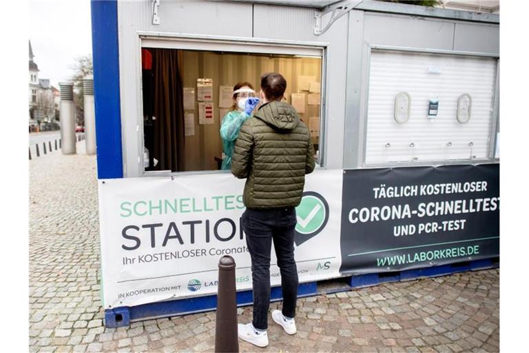 Eine Mitarbeiterin einer Teststation in der Oldenburger Innenstadt nimmt einen Abstrich von einem jungen Mann. (Archivbild). Foto: Hauke-Christian Dittrich/dpa