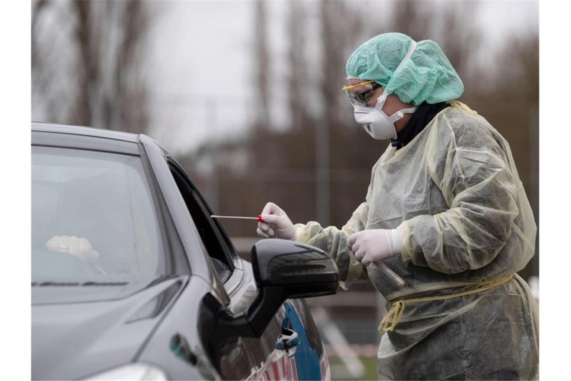 Eine Mitarbeiterin eines Krankenhauses nimmt zum Start einer "Drive-In"-Teststation für den Coronavirus eine Probe. Foto: Marijan Murat/dpa