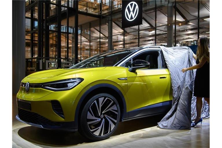 Eine Mitarbeiterin enthüllt während der Vorstellung in der Gläsernen Manufaktur einen ID.4 von Volkswagen, dem ersten Elektro-SUV der Marke. (Archivbild). Foto: Robert Michael/dpa-Zentralbild/dpa