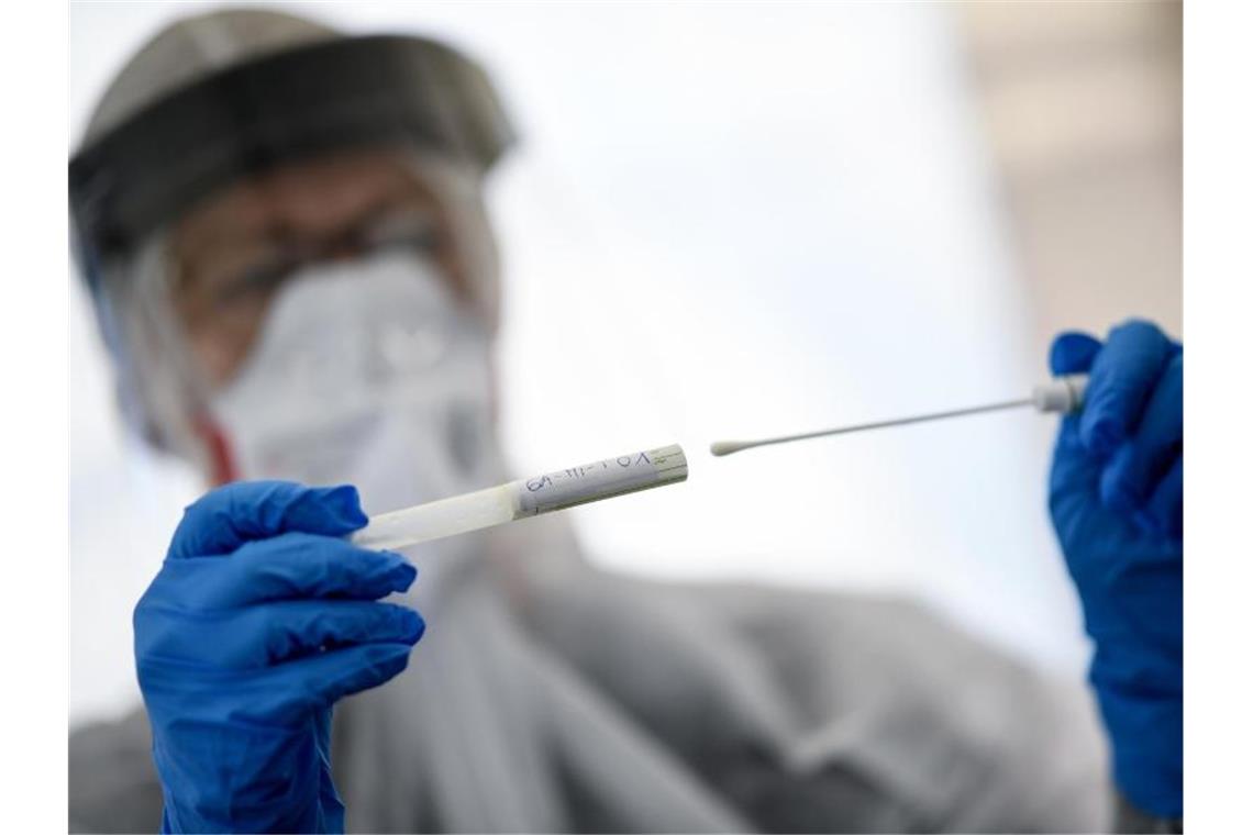 Eine Mitarbeiterin hält ein Abstrichstäbchen in einer Corona-Test-Einrichtung in der Hand. Foto: Britta Pedersen/dpa-Zentralbild/dpa/Symbolbild