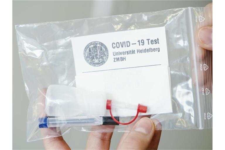 Eine Mitarbeiterin hält ein Testkit des Gurgeltests in den Händen. Foto: Uwe Anspach/dpa