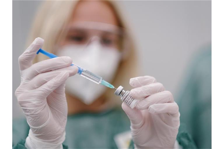 Eine Mitarbeiterin im Gesundheitswesen zieht eine Spritze mit Covid-19-Impfstoff auf. Foto: Ole Spata/dpa