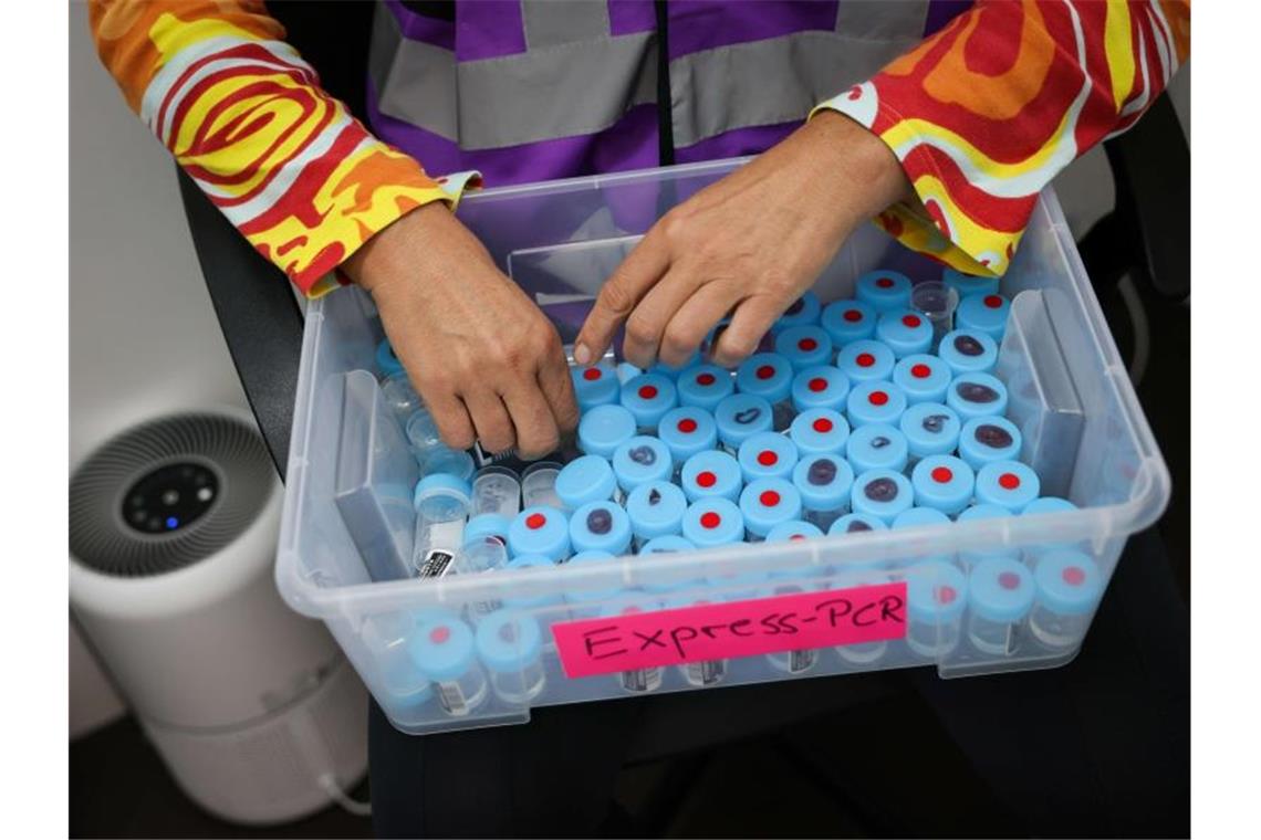 RKI registriert 4171 Corona-Neuinfektionen Eine Mitarbeiterin sortiert noch unbenutzte Behälter für einen PCR-Gurgeltest in einem Testcenter für Corona-Schnelltests (Antigentest) und Corona-PCR-Tests. Foto: Christian Charisius/dpa