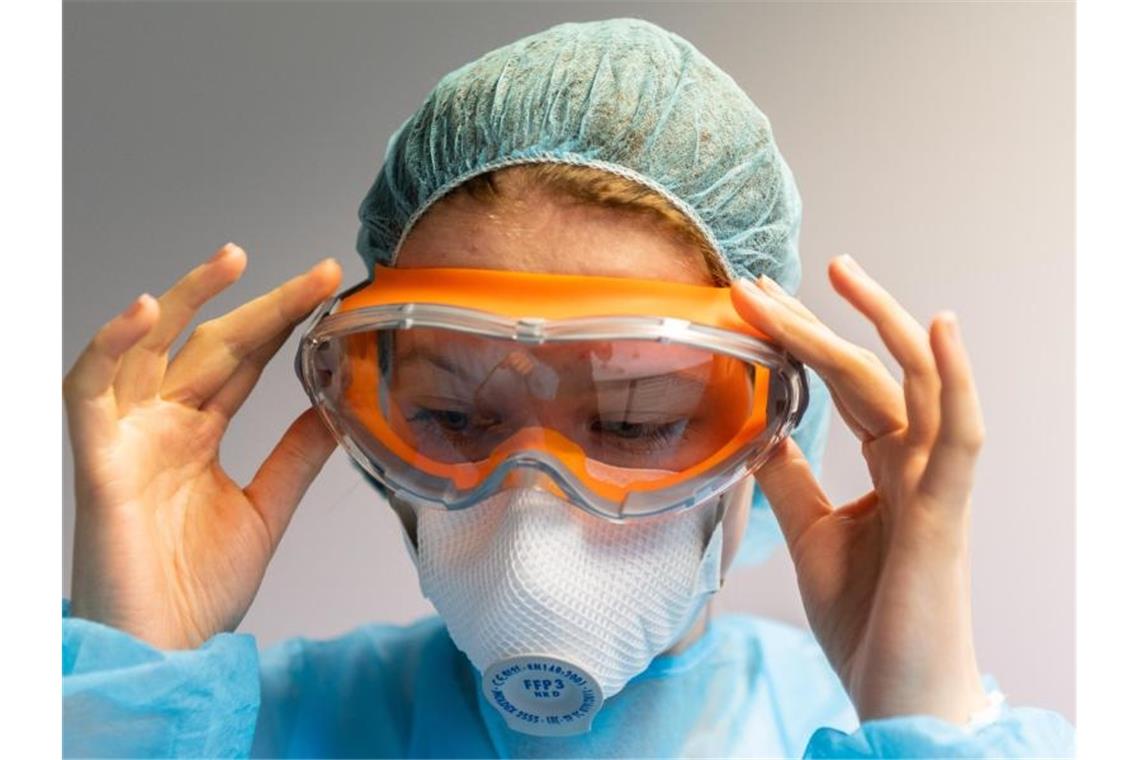 Quarantänezentrum für Flüchtlinge geht am Samstag in Betrieb Eine Mitarbeiterin trägt Schutzkleidung um eine Ansteckung zu verhindern. Foto: Robert Michael/dpa-Zentralbild/dpa/Symbolbild