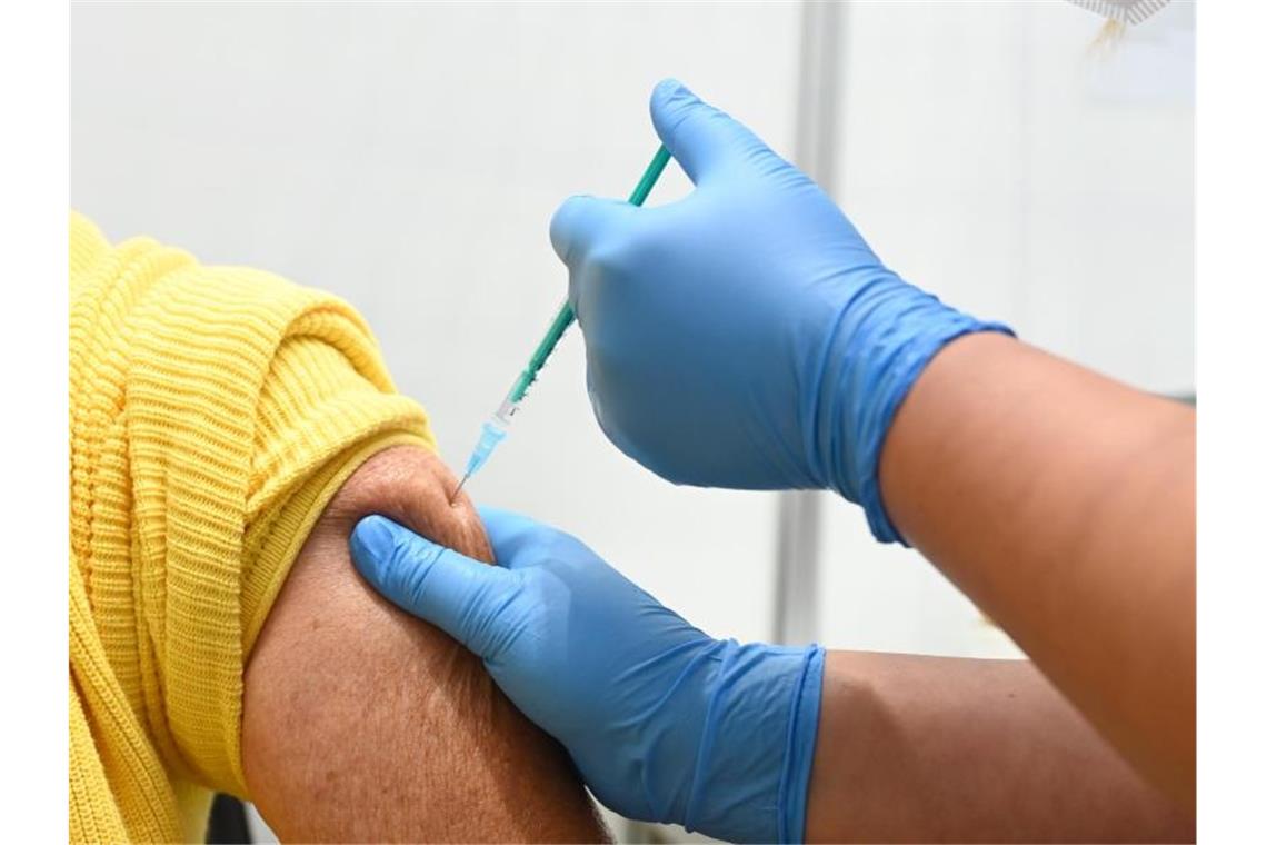 Eine Mitarbeiterin vom Impfzentrum am Robert-Bosch-Krankenhaus verabreicht eine Auffrischimpfung gegen das Coronavirus. Foto: Bernd Weißbrod/dpa