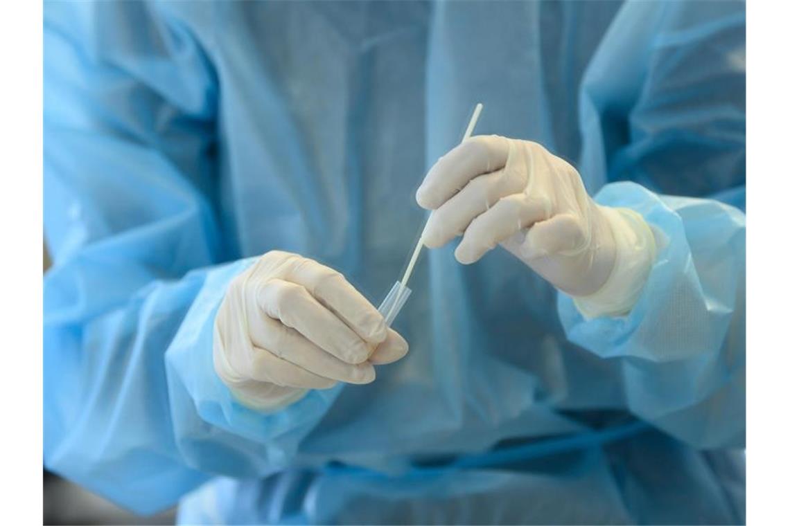 Eine Mitarbeiterin wertet einen Antigen-Schnelltest auf das Coronavirus aus. Foto: Robert Michael/dpa-Zentralbild/dpa