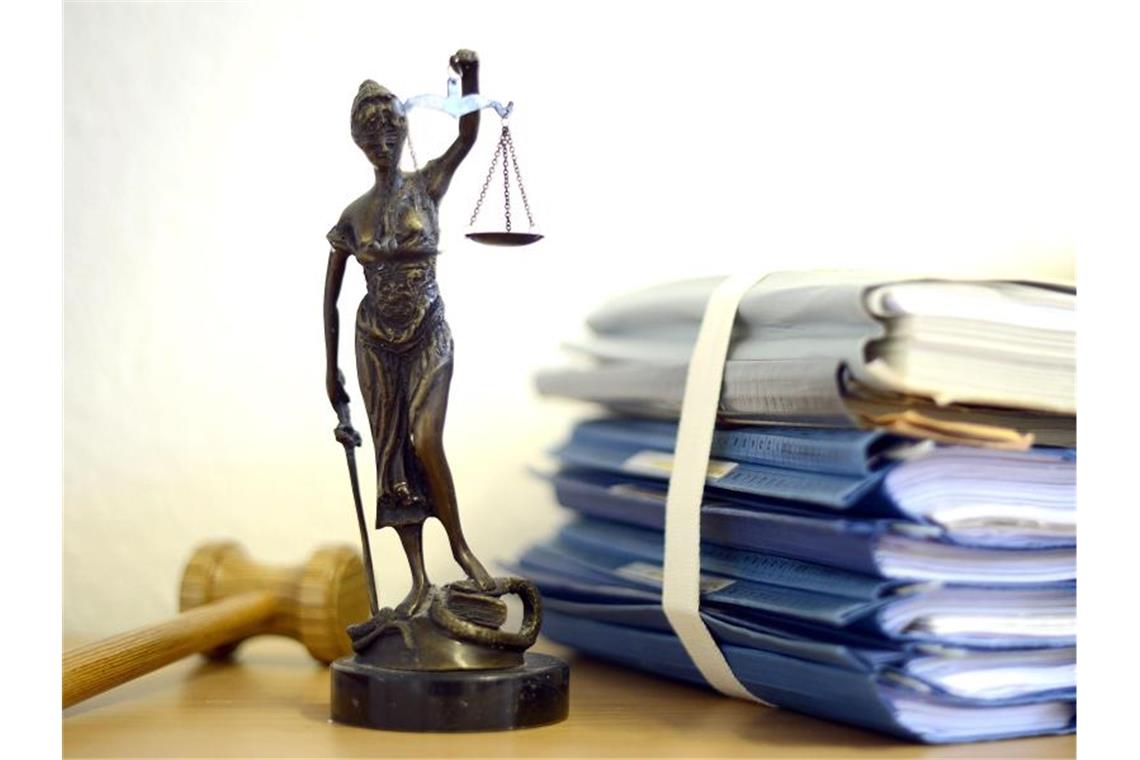 Zoff um Lärm: „Menschen kann man nicht verbieten“ Eine modellhafte Nachbildung der Justitia neben Aktenordnern. Foto: Volker Hartmann/dpa/Archivbild
