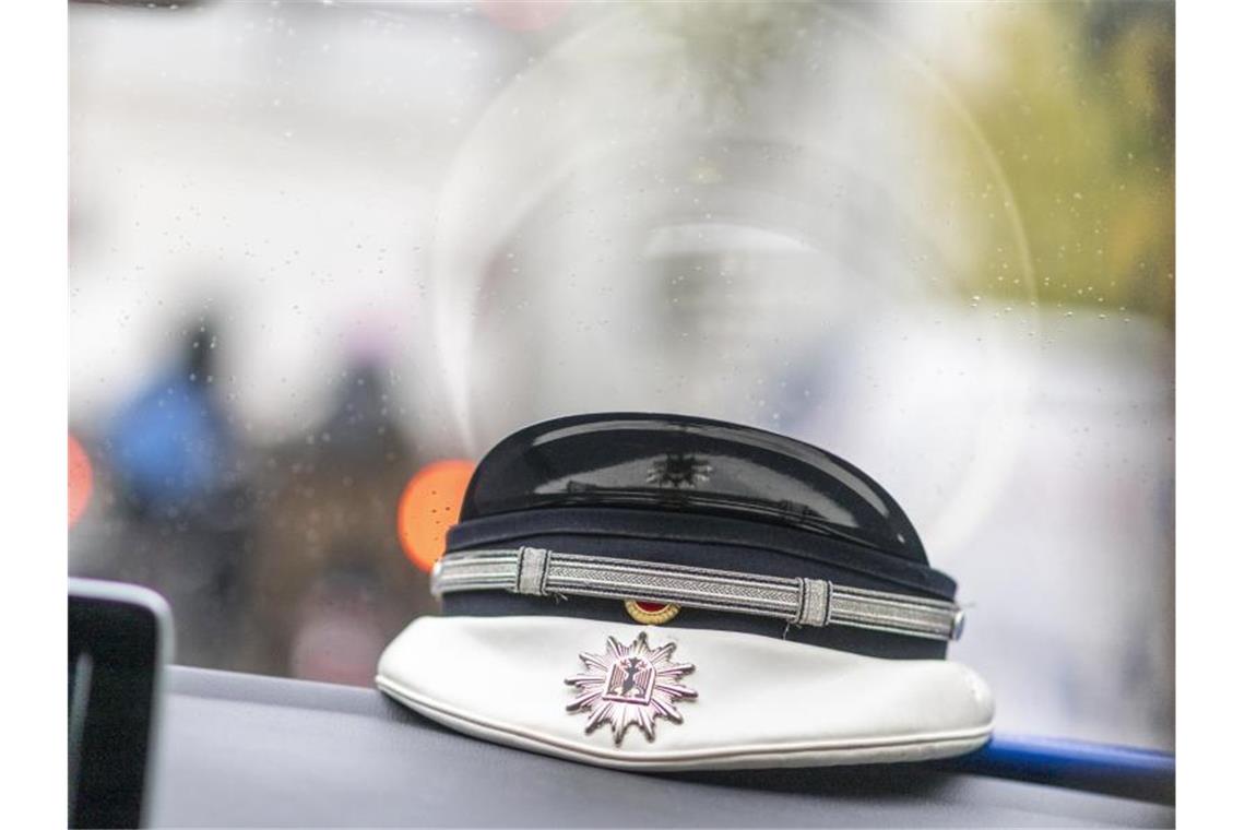 Eine Mütze eines Bundespolizisten liegt auf einem Armaturenbrett. Foto: Patrick Seeger/dpa