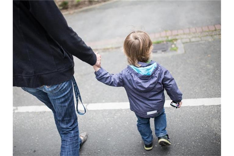 Eine Mutter hält ihren Sohn an der Hand. Der Kinderbonus hat sich als effektive Konjunkturhilfe erwiesen. Foto: Marcel Kusch/dpa