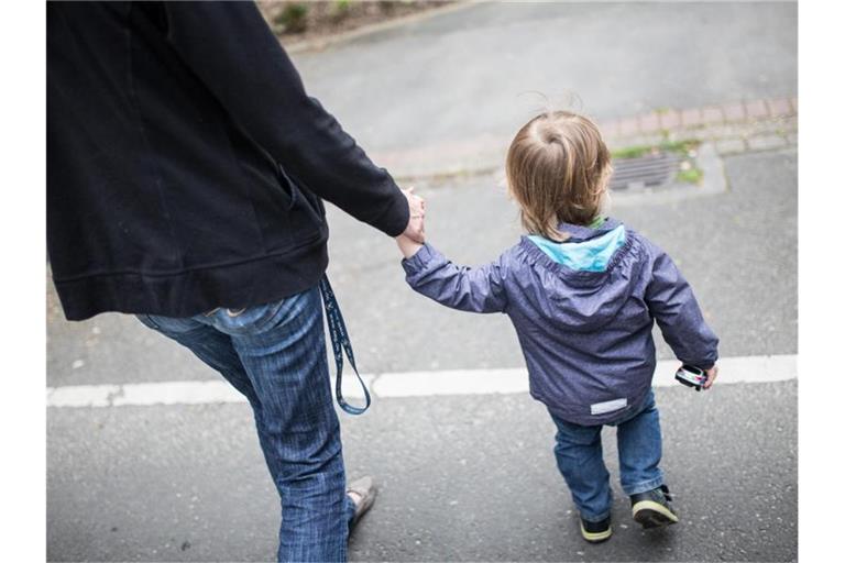 Eine Mutter hält ihren Sohn an der Hand. Foto: picture alliance / Marcel Kusch/dpa
