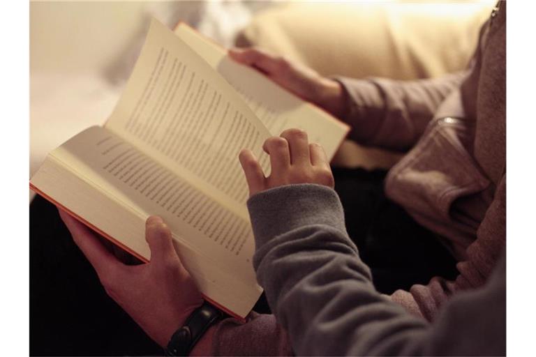 Eine Mutter liest ihrer Tochter aus einem Buch vor. Foto: Hans-Thomas Frisch/dpa/Illustration