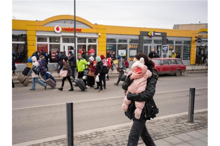 Eine Mutter mit ihrem Kind auf einer Straße in Lwiw während Luftalarm-Sirenen ertönen. Foto: Pau Venteo/EUROPA PRESS/dpa