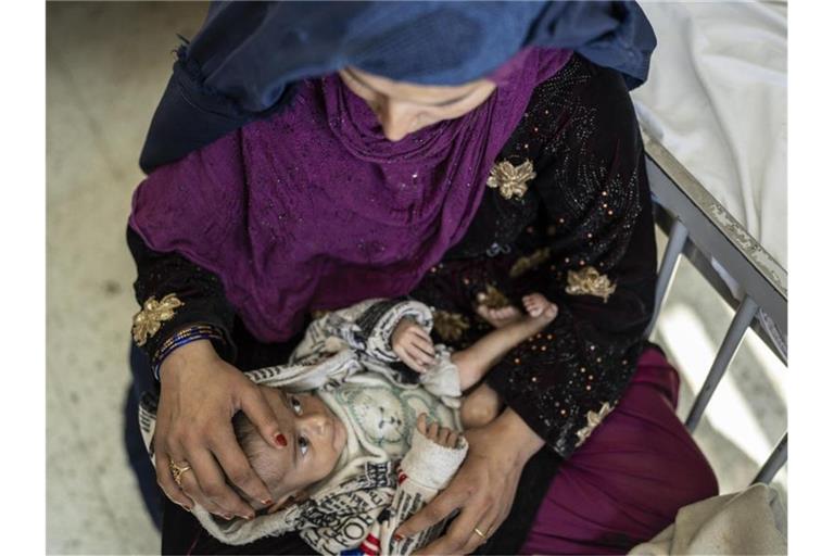 Eine Mutter mit ihrem vier Monate alten Baby auf einer Station für Unterernährung in Afghanistans Haupstadt Kabul. Foto: Petros Giannakouris/AP/dpa