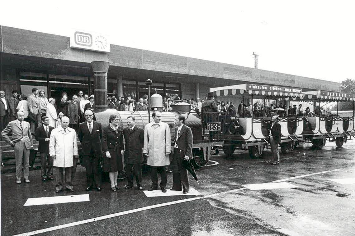 Backnanger Bahnhofsgebäude wird 50 Jahre alt Eine Nachbildung des „Adlers“ pendelte bei der Eröffnung zwischen Bahnhof und Schillerplatz. Vorne posieren unter anderem der Landtagsabgeordnete Erich Schneider (vorne links im hellen Mantel), Oberbürgermeister Martin Dietrich (Dritter von rechts) und der CDU-Bundestagsabgeordnete Dieter Schulte (Zweiter von rechts). Ganz rechts mit Schirm steht der Abgeordnete Giselher Gruber. Archivbild: Stadtarchiv Backnang