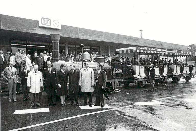 Eine Nachbildung des „Adlers“ pendelte bei der Eröffnung zwischen Bahnhof und Schillerplatz. Vorne posieren unter anderem der Landtagsabgeordnete Erich Schneider (vorne links im hellen Mantel), Oberbürgermeister Martin Dietrich (Dritter von rechts) und der CDU-Bundestagsabgeordnete Dieter Schulte (Zweiter von rechts). Ganz rechts mit Schirm steht der Abgeordnete Giselher Gruber. Archivbild: Stadtarchiv Backnang
