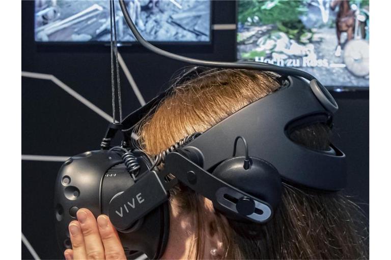 Eine Nutzerin der Ausstellung hat im Expolab eine VR-Brille auf, mit der man in vergangene Welten eintauchen kann. Foto: Uli Deck//Archivbild