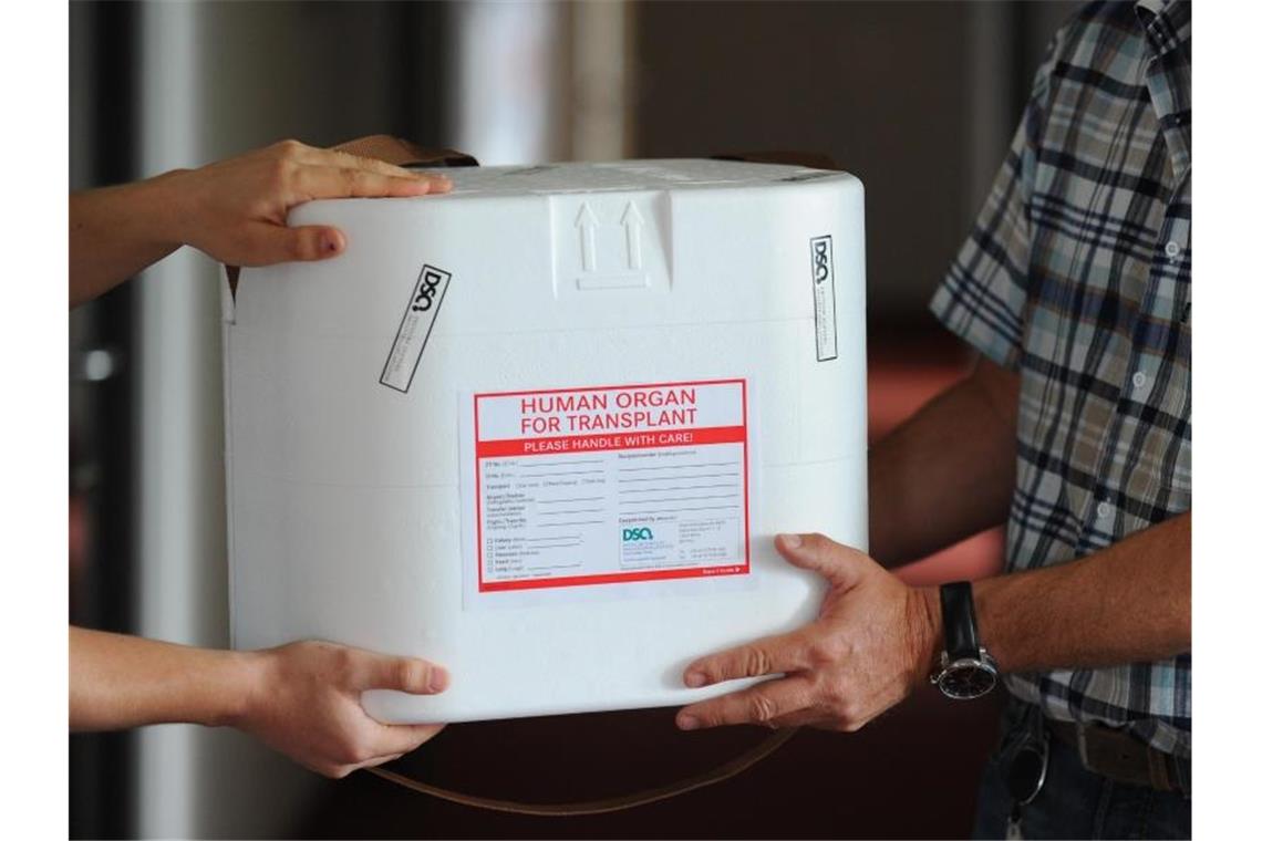 Eine Organtransportbox wird übergeben. Foto: Jens Kalaene/dpa-Zentralbild/dpa/Archivbild