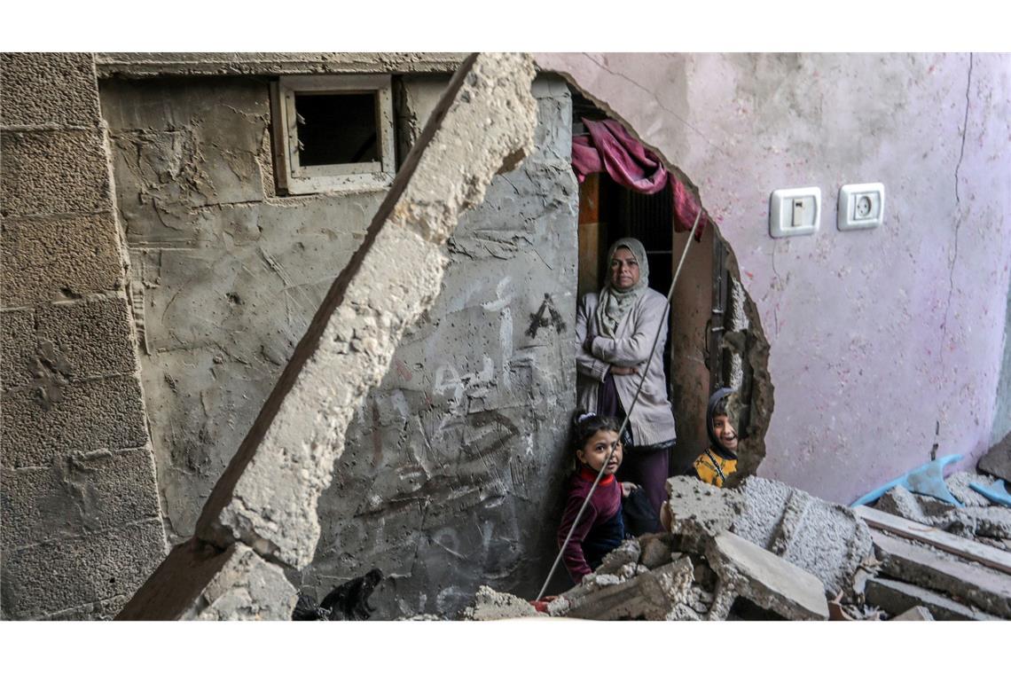 Eine palästinensische Frau mit ihren Kindern inmitten ihres zerstörten Hauses nach einem israelischen Bombardement in Rafah.