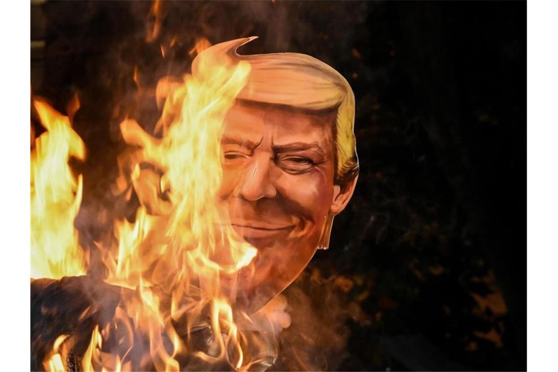 Eine Papp-Nachbildung des Kopfes von US-Präsident Trump wird während eines Protestes in Kalkutta verbrannt. Foto: Debarchan Chatterjee/ZUMA Wire/dpa