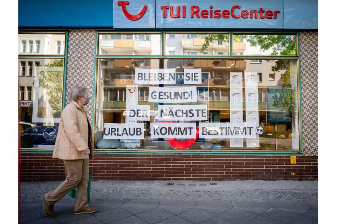 Kretschmer bleibt dabei: Kein Osterurlaub in diesem Jahr Eine Passantin mit Maske geht an einem Reisebüro vorbei. Der Betreiber hat den Hinweis „Bleiben Sie gesund! Der nächste Urlaub kommt bestimmt“ in sein Schaufenster gehängt. Foto: Kay Nietfeld/dpa