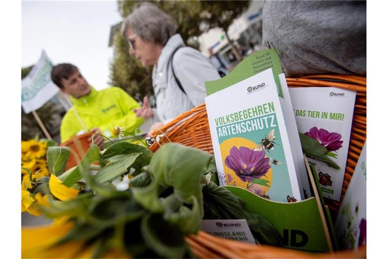 Eine Passantin unterhält sich während einer Unterschriftensammlung für das Volksbegehren mit Naturschützern. Foto: Marijan Murat/dpa