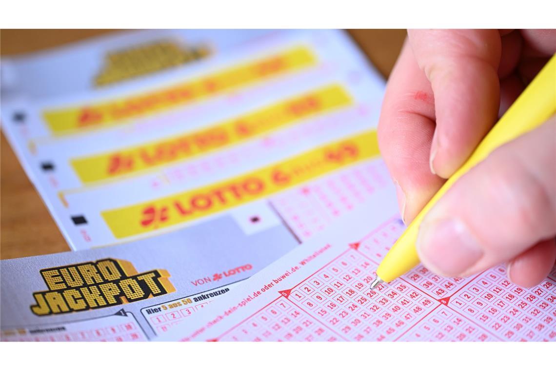 Eine Person füllt einen Lottoschein aus (Symbolbild).