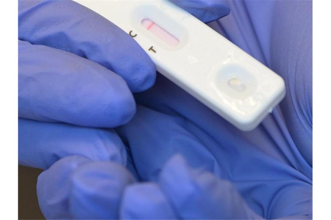 Eine Person hält während eines Corona-Tests den Plastikstreifen mit dem negativen Testergebnis in der Hand. Foto: Soeren Stache/dpa-Zentralbild/dpa