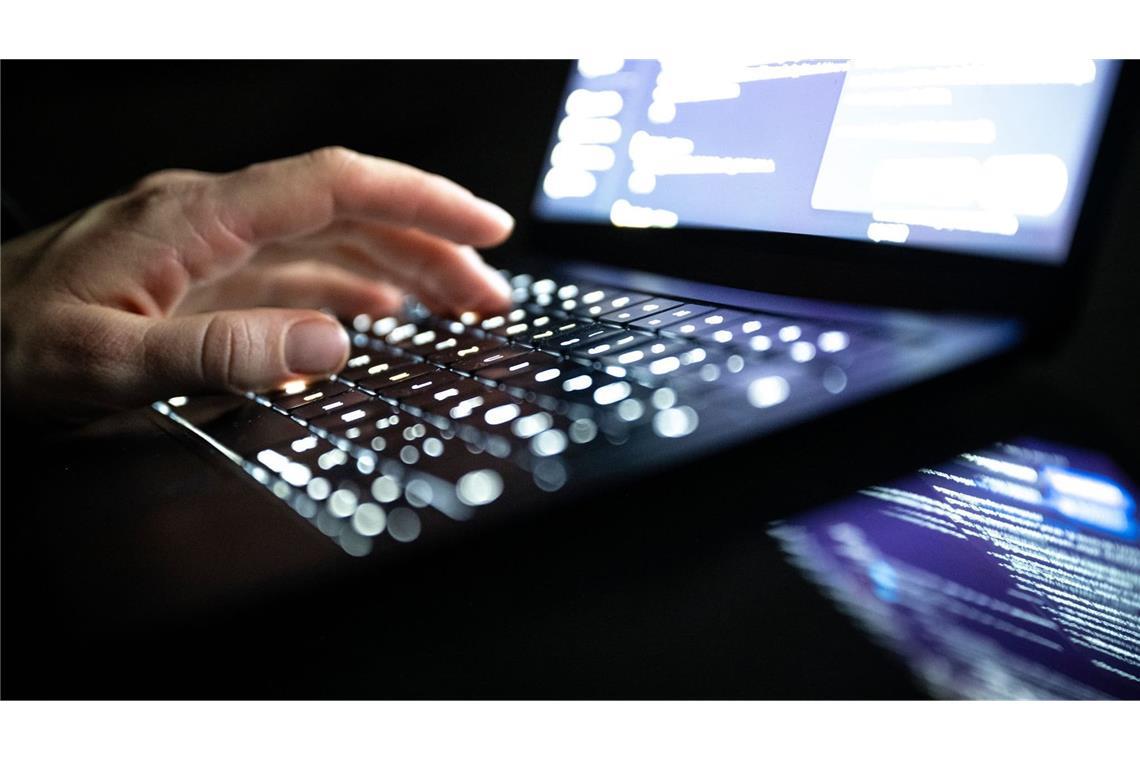 Eine Person tippt mit den Fingern auf einer beleuchteten Laptop-Tastatur. (gestellte Szene) (zu dpa: «Hacker brechen in CDU-Account ein und senden Mail an Merz»)
