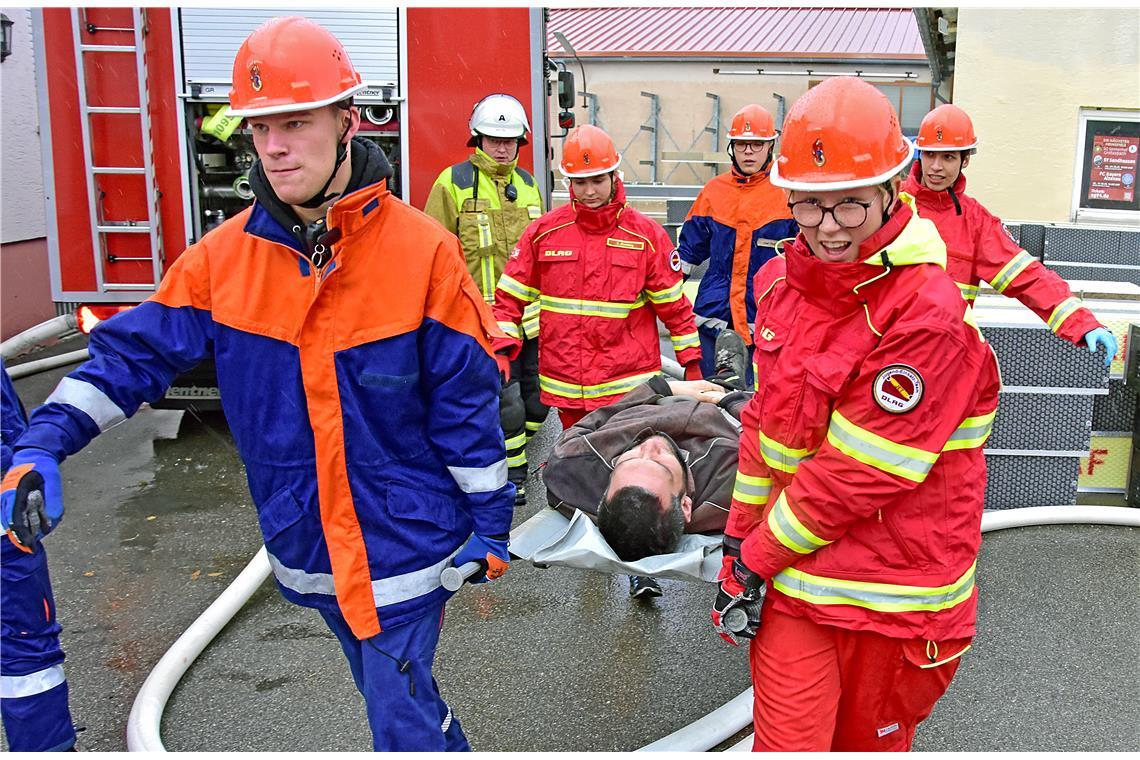 Eine Person wird von der DLRG und der Jugendfeuerwehr aus dem Gefahrenbereich ge...