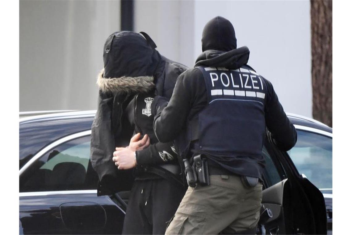 Nach Razzien: Rechte Terrorverdächtige in Untersuchungshaft Eine Person wird von Polizisten in den Bundesgerichtshof gebracht. Foto: Uli Deck/dpa