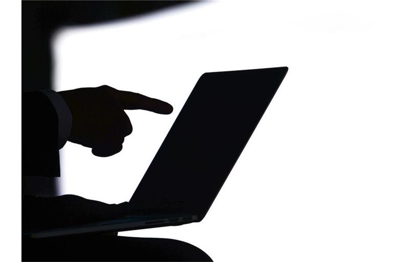 Eine Person zeigt auf den Bildschirm eines Laptops. Foto: Ralf Hirschberger/Archivbild