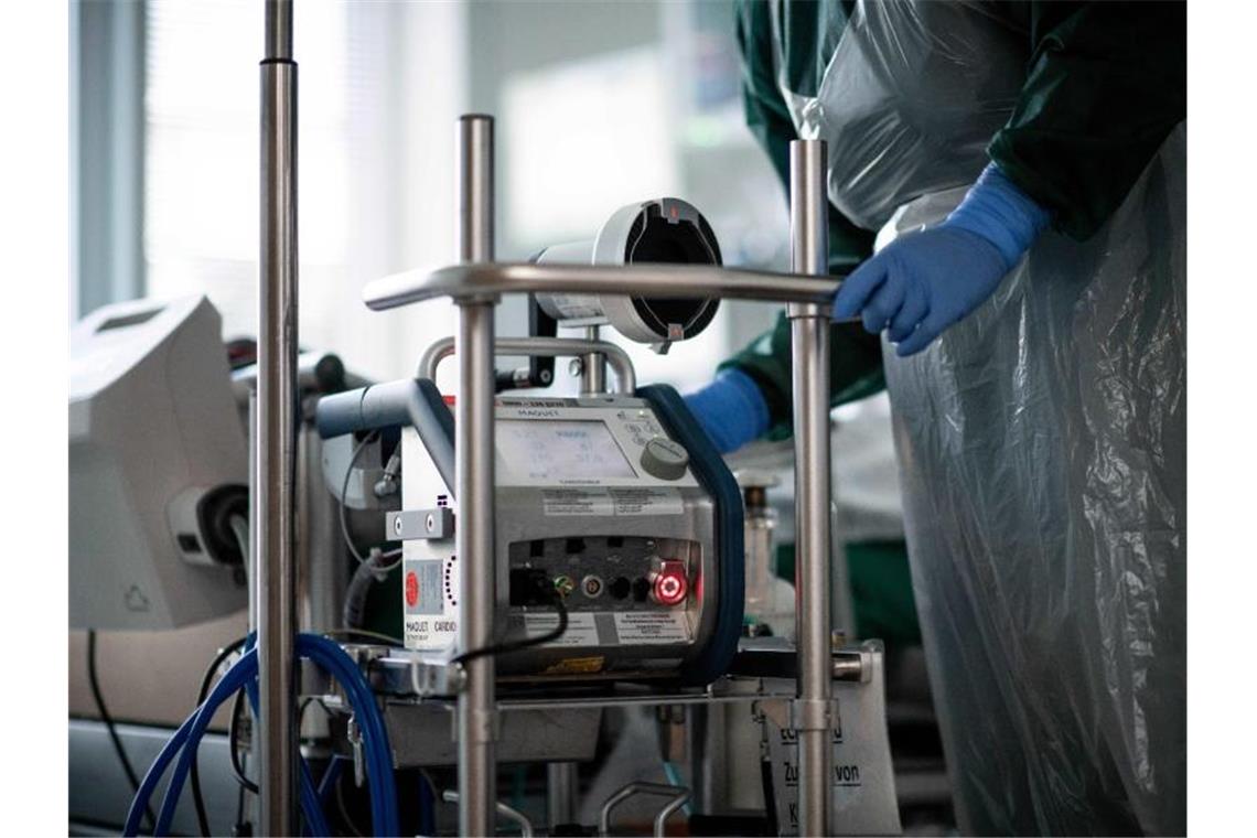 Weniger Covid-Patienten auf Intensivstationen Eine Pflegekraft steht auf einer Intensivstation in einem Zimmer und bedient eine Herz-Lungen-Maschine. Foto: Fabian Strauch/dpa/Symbolbild