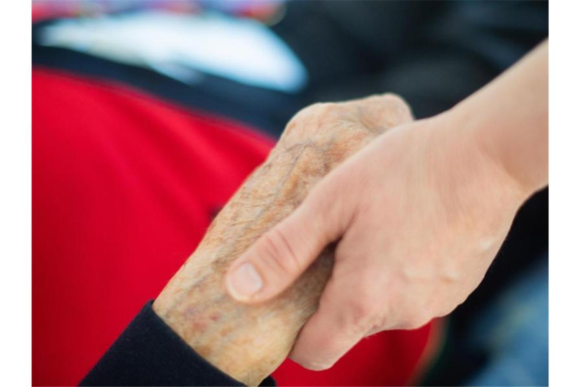 Neues Projekt unterstützt Gesundheitsmanagement in Pflege Eine Pflegerin hält in einem Pflegeheim die Hand einer Bewohnerin. Foto: Tom Weller/dpa/Archivbild