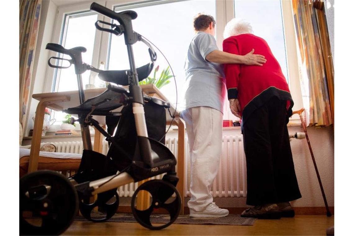 Gesundheitskräfte senden Brandbrief an Landesregierung Eine Pflegerin und eine Bewohnerin des Pflegeheims schauen aus dem Fenster. Foto: Tom Weller/dpa/Symbolbild