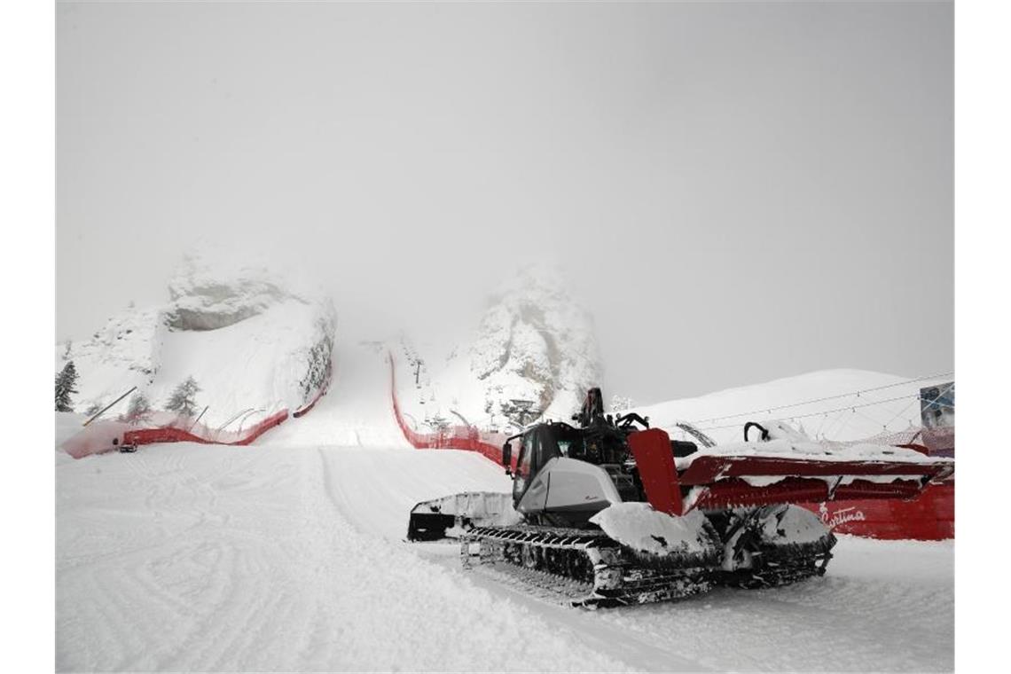 WM-Schneechaos in Cortina: Zwei Rennen verschoben Eine Pistenraupe beseitigt in Cortina d'Ampezzo Neuschnee an der Strecke. Foto: Gabriele Facciotti/AP/dpa