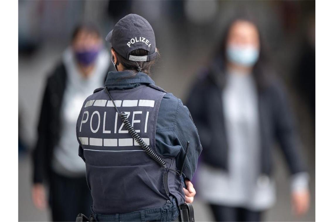 Polizei löst AfD-Gegendemo auf: Aktivist greift Beamte an Eine Polizistin Blickt zu Passanten mit Masken. Foto: Sebastian Gollnow/dpa/Symbolbild