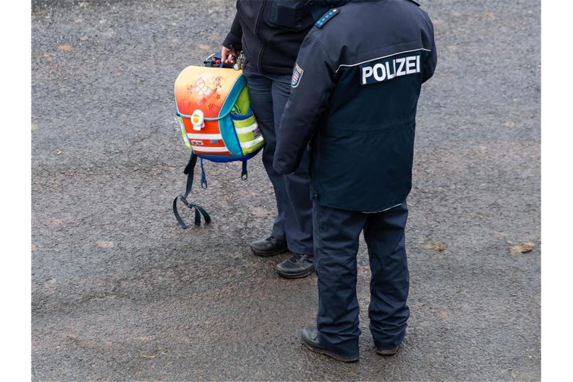 Eine Polizistin hat einen Schulranzen sichergestellt. Foto: Swen Pförtner/dpa