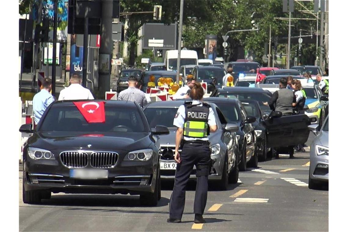 Eine Polizistin steht vor den Fahrzeugen eines türkischen Hochzeutskorsos. Der Konvoi war einer von dreien, den die Polizei in der Rheinmetropole am Wochenende angehalten hat. Foto: Thomas Kraus