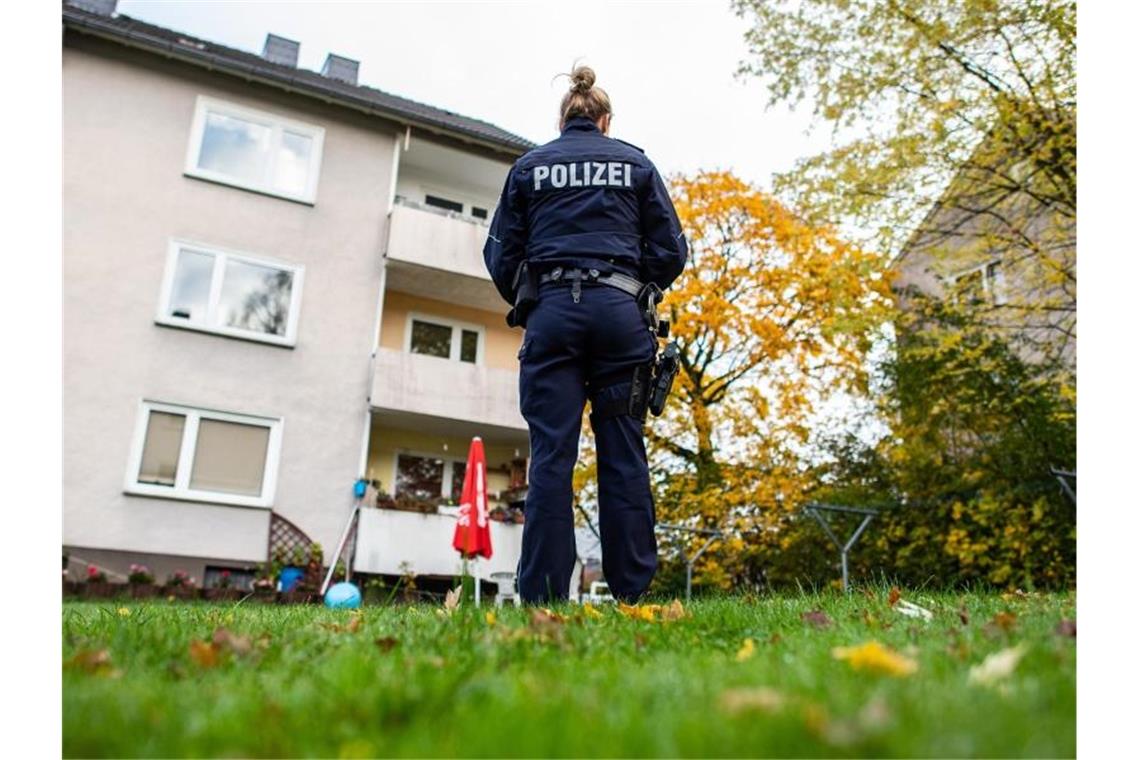 Eine Polizistin vor dem Mehrfamilienhaus in Detmold, in dem eine 15-Jährige ihren dreijährigen Halbbruder erstochen haben soll. Foto: Guido Kirchner/dpa
