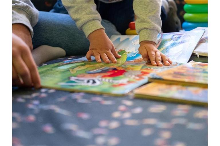 Eine Praktikantin liest in einer Kita Kindern vor. Foto: Sebastian Gollnow/dpa/Illustration