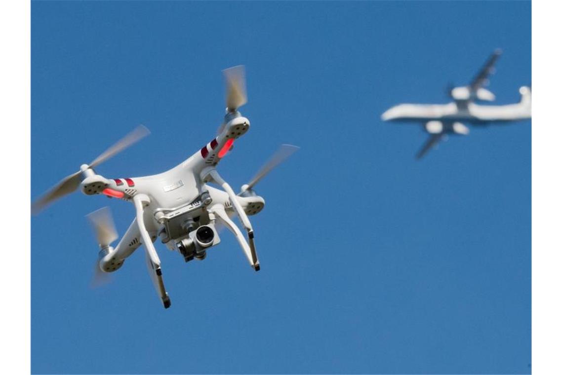 Eine private Drohne fliegt in in der Nähe eines Flugzeugs. Foto: Julian Stratenschulte/Archiv/dpa