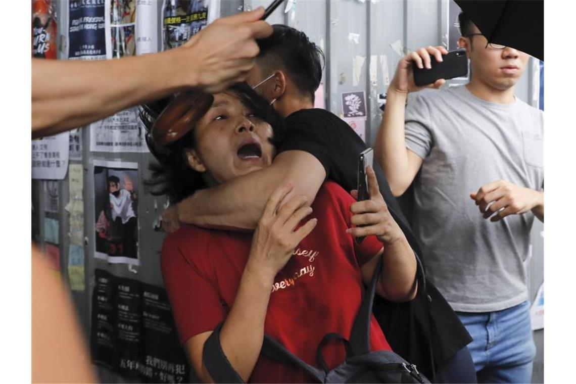 Polizei verhindert Proteste in Hongkong Eine Pro-China-Demonstrantin wird von einem regierungskritischen Demonstranten attackiert. Foto: Kin Cheung/AP