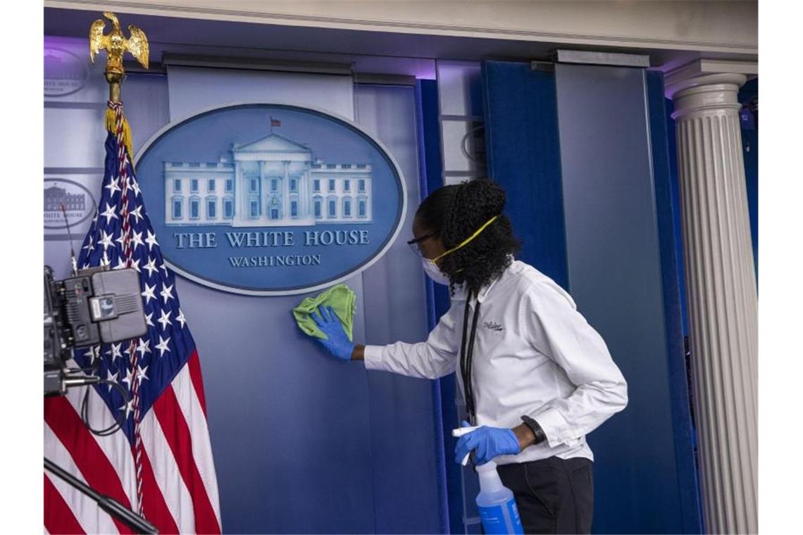 Eine Reinigungskraft macht in einem Pressebriefing-Raum des Weißen Hauses sauber (Archiv). Foto: Alex Brandon/AP/dpa