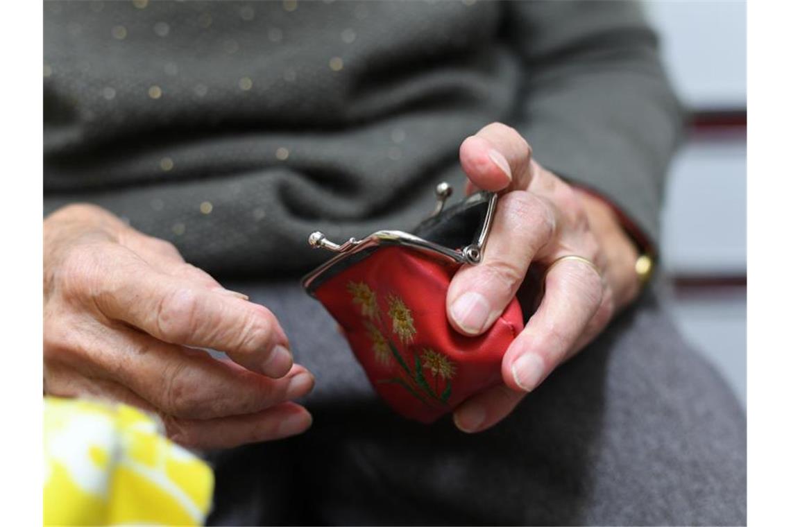 Eine Rentnerin blickt in ihren Geldbeutel. Foto: picture alliance / Felix Kästle/dpa