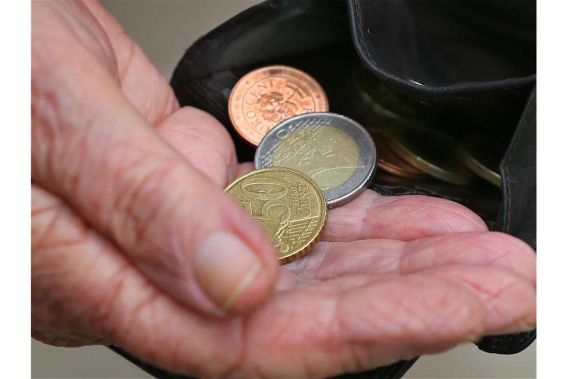 Eine Rentnerin hält einen Geldbeutel mit verschiedenen Euromünzen. Foto: Karl-Josef Hildenbrand/dpa