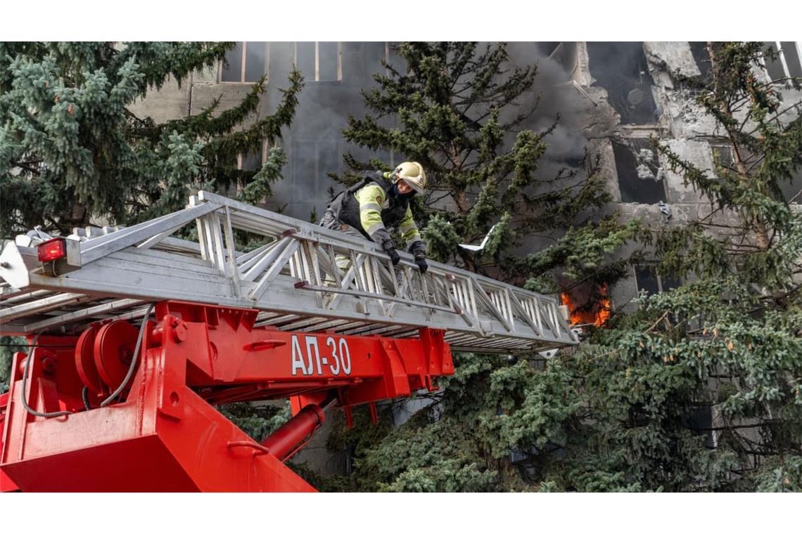 Eine Rettungskraft löscht einen Brand in einer medizinischen Einrichtung, die bei einem russischen Angriff auf Charkiw beschädigt wurde.