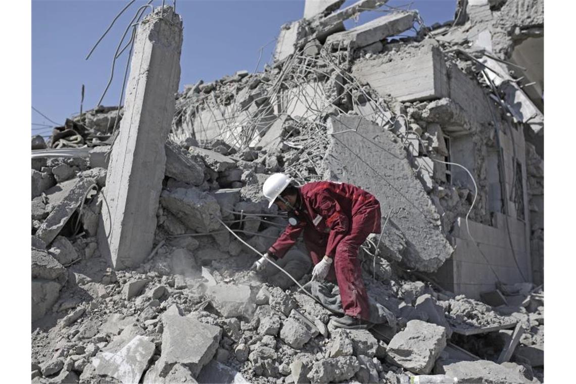 Eine Rettungskraft sucht in den Trümmern eines Gefangenenlagers nach verschütteten Leichen. Foto: Hani Mohammed/AP