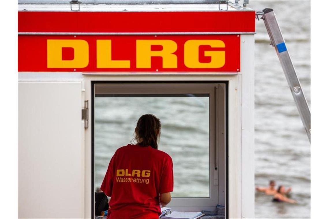 Eine Rettungsschwimmerin der DLRG steht vor dem Fenster eines Wachturms. Foto: Mohssen Assanimoghaddam/dpa/Symbolbild