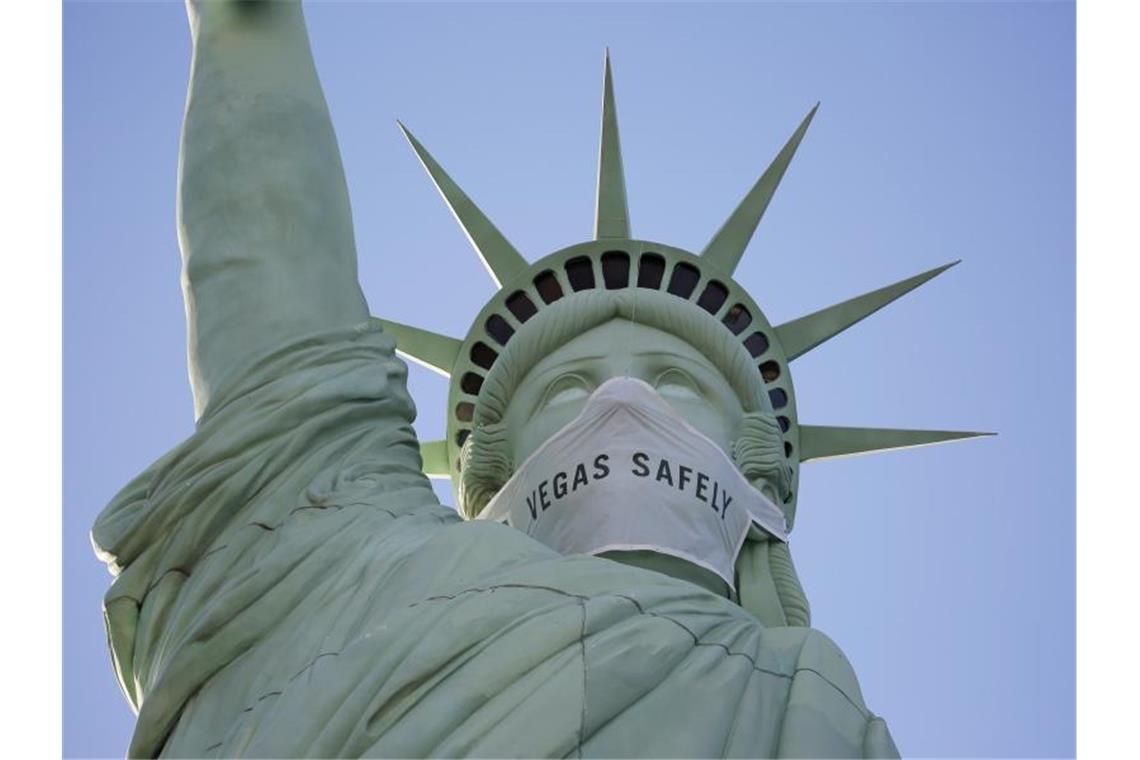 US-Experten fordern neue strikte Ausgangsbeschränkungen Eine riesige Maske ziert das Gesicht der Freiheitsstatue-Nachbildung in Las Vegas. Foto: John Locher/AP/dpa