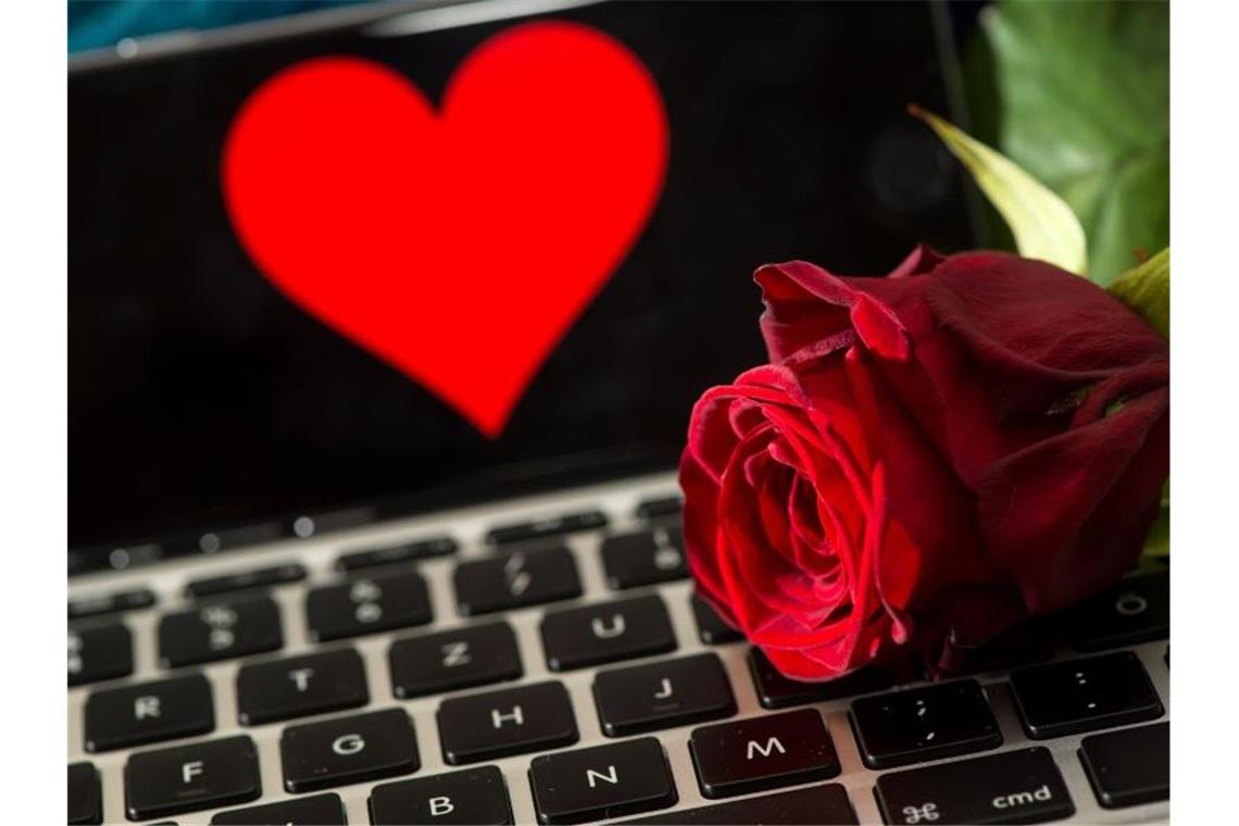 Eine Rose liegt auf einer Computertastatur. Foto: picture alliance / dpa/Archivbild